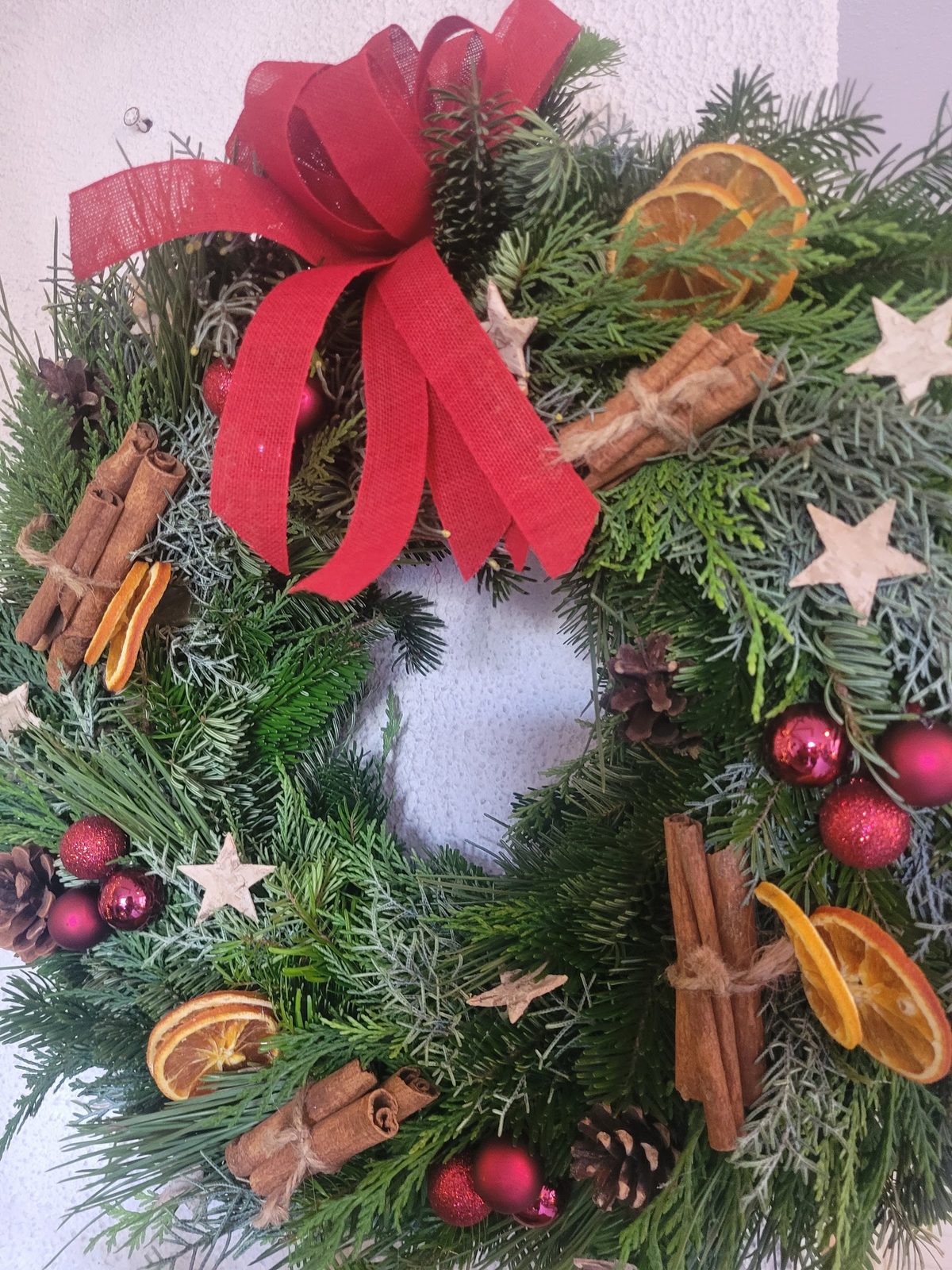 Couronne de l’Avent : sapin, oranges séchées et ruban rouge